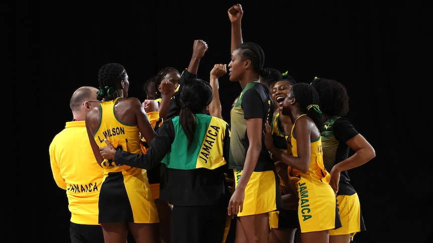 Jamaica's netball team gather in a huddle to celebrate beating Australia.