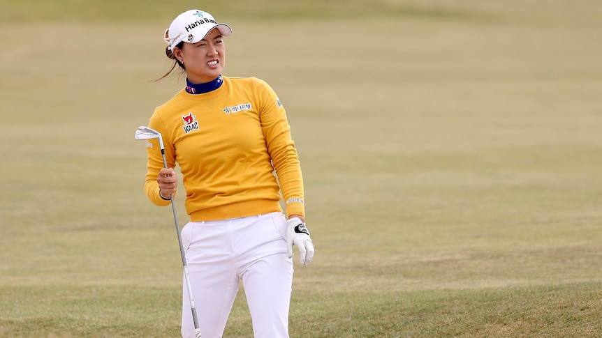 Australia's Minjee Lee holds her club in her hand as she looks down the fairway after hitting an approach shot.
