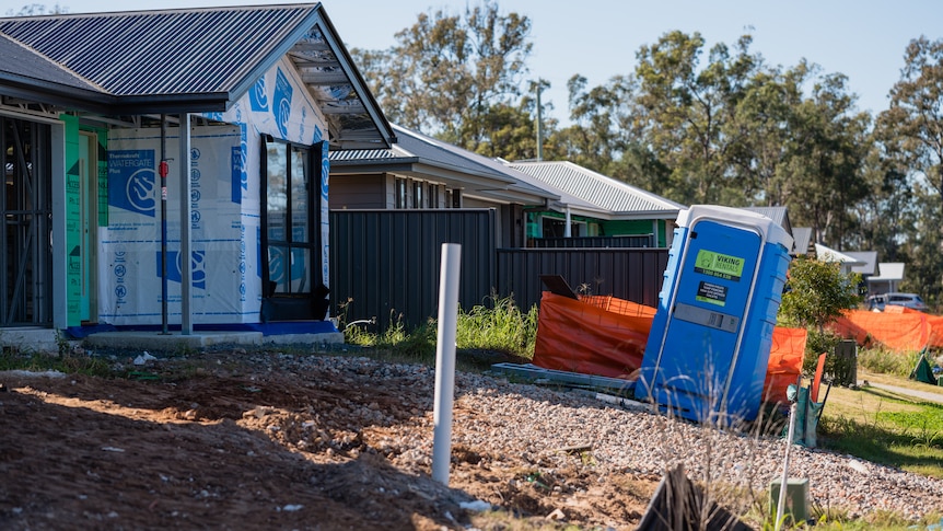 Portable toilet outside house under construction