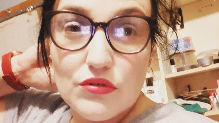 A woman with brown hair and glasses