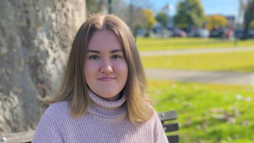 A woman sitting on a bench in a park