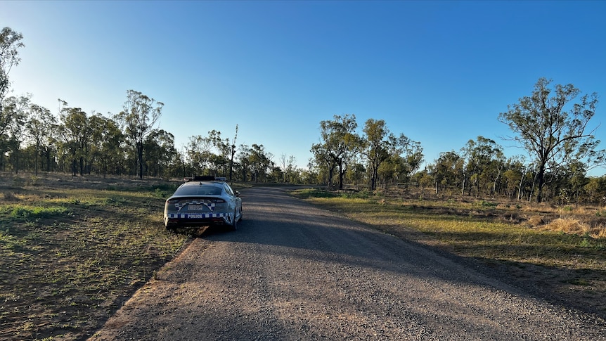 A police car on a dirt road near.