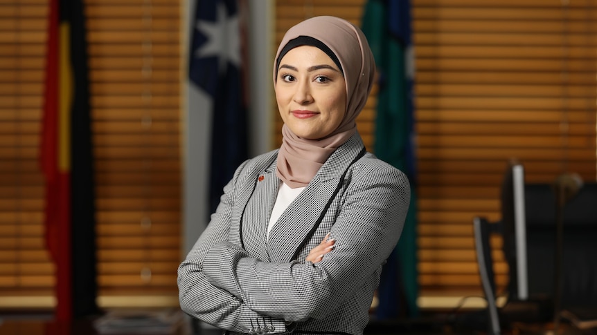 Fatima Payman stands with her arms crossed inside her Parliament House office.