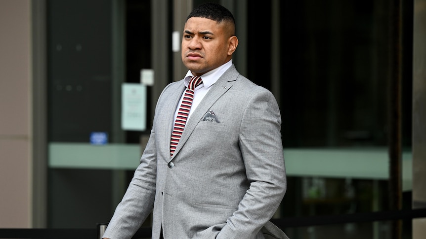 A Manly NRL player stands outside Parramatta District Court.