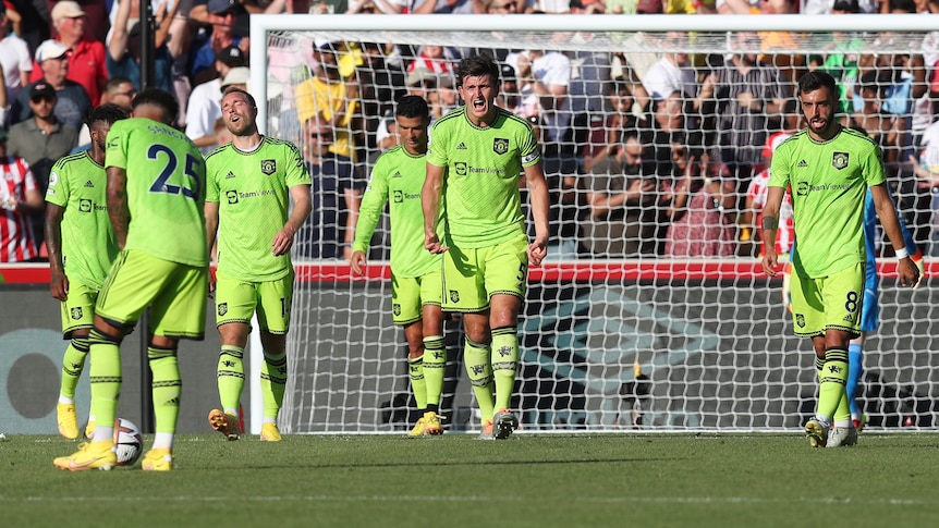 Manchester United players close their eyes or shout in frustration as they walk back to the centre circle after a goal.