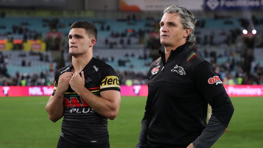 Penrith Panthers coach Ivan Cleary (right) walks with halfback Nathan Cleary on the field after losing the 2020 NRL grand final.