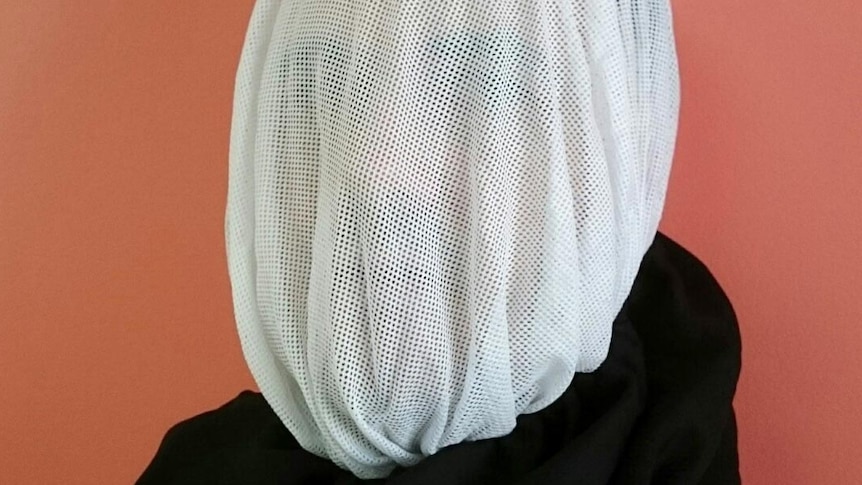 A man wearing a gauze hood on his head.
