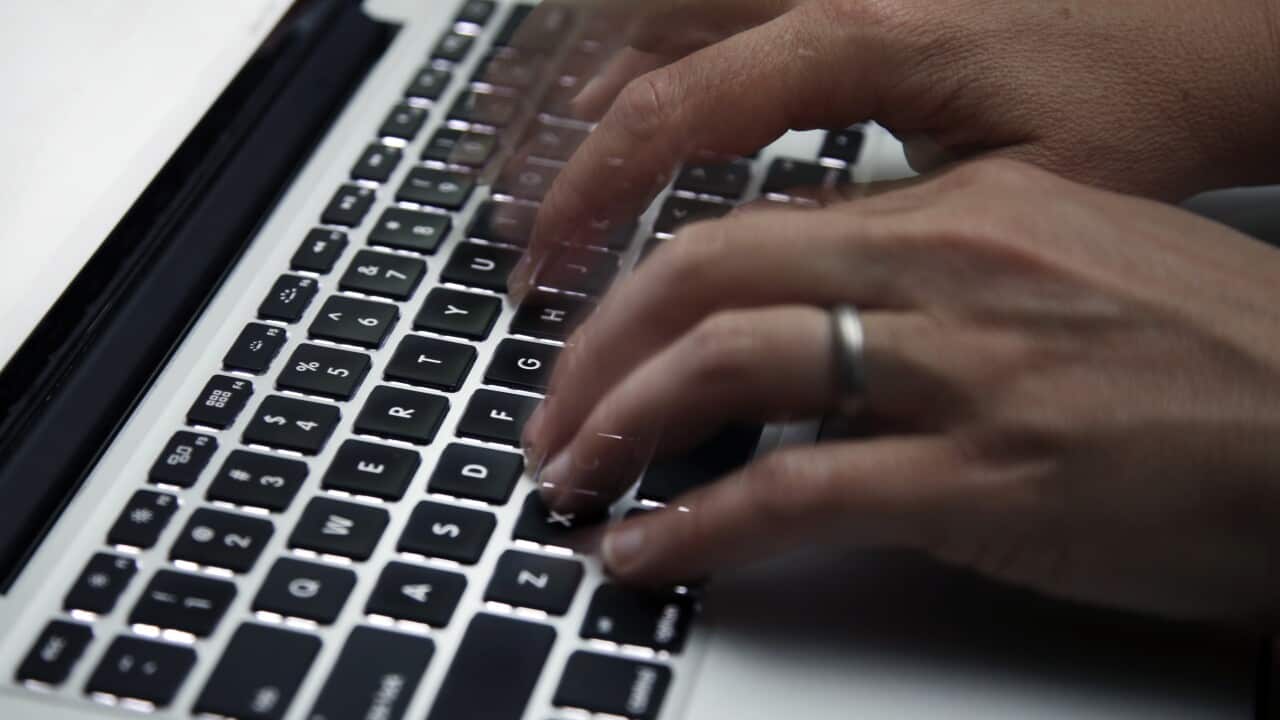 A person's hands typing on a computer keyboard.