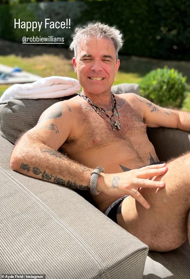 Cheeky: Robbie Williams looked happy and relaxed as he kicked back in the garden, wearing just a miniscule pair of Calvin Klein underpants on Tuesday